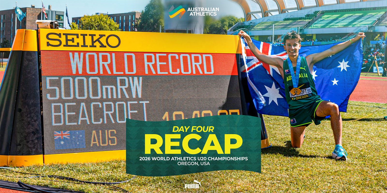 Australian athlete kneels on grass with an Australian flag draped behind, beside a large scoreboard that reads 'World Record 5000m RW'; a green banner says 'DAY FOUR RECAP' for the 2026 World Athletics U20 Championships in Oregon.